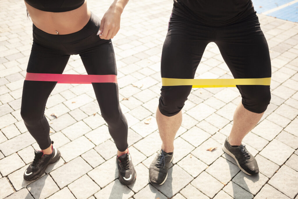 sportowcy pod wysokim katem wykonujacy cwiczenia z gumka